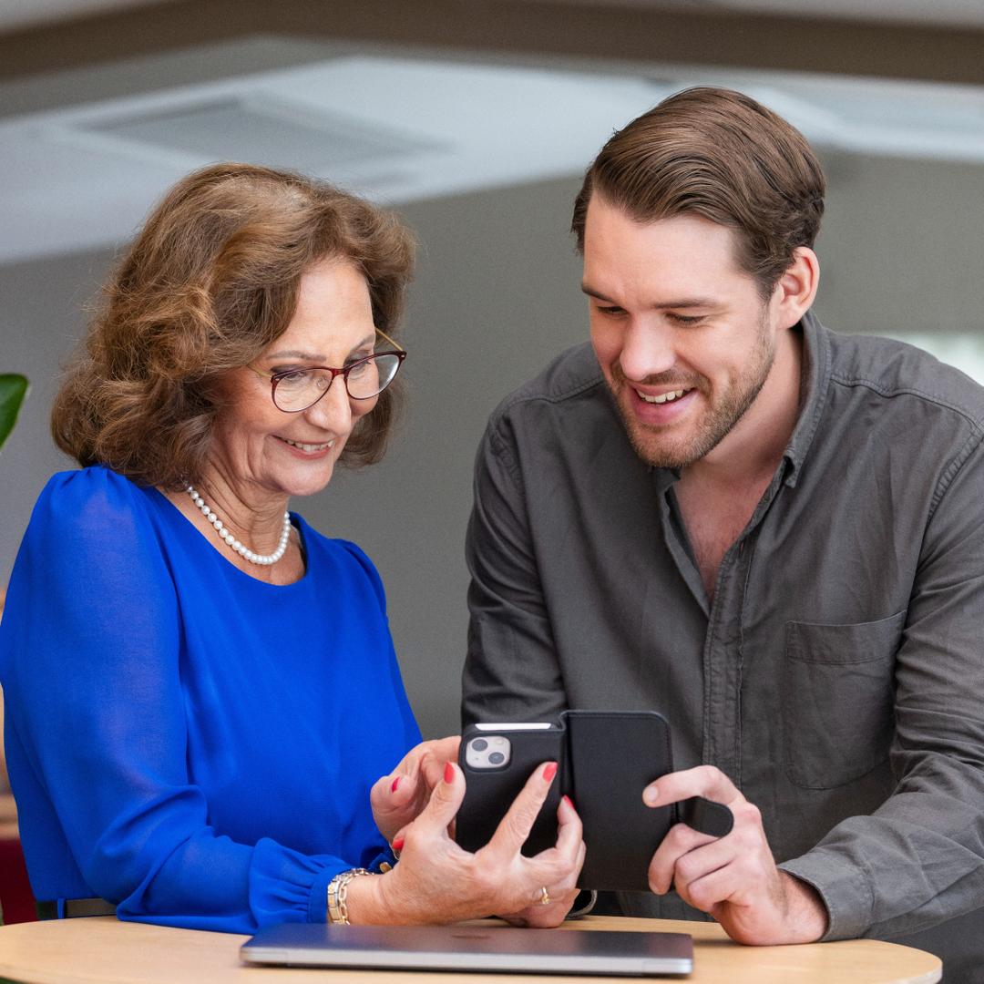 Bild som visar två personer som tittar på en telefon